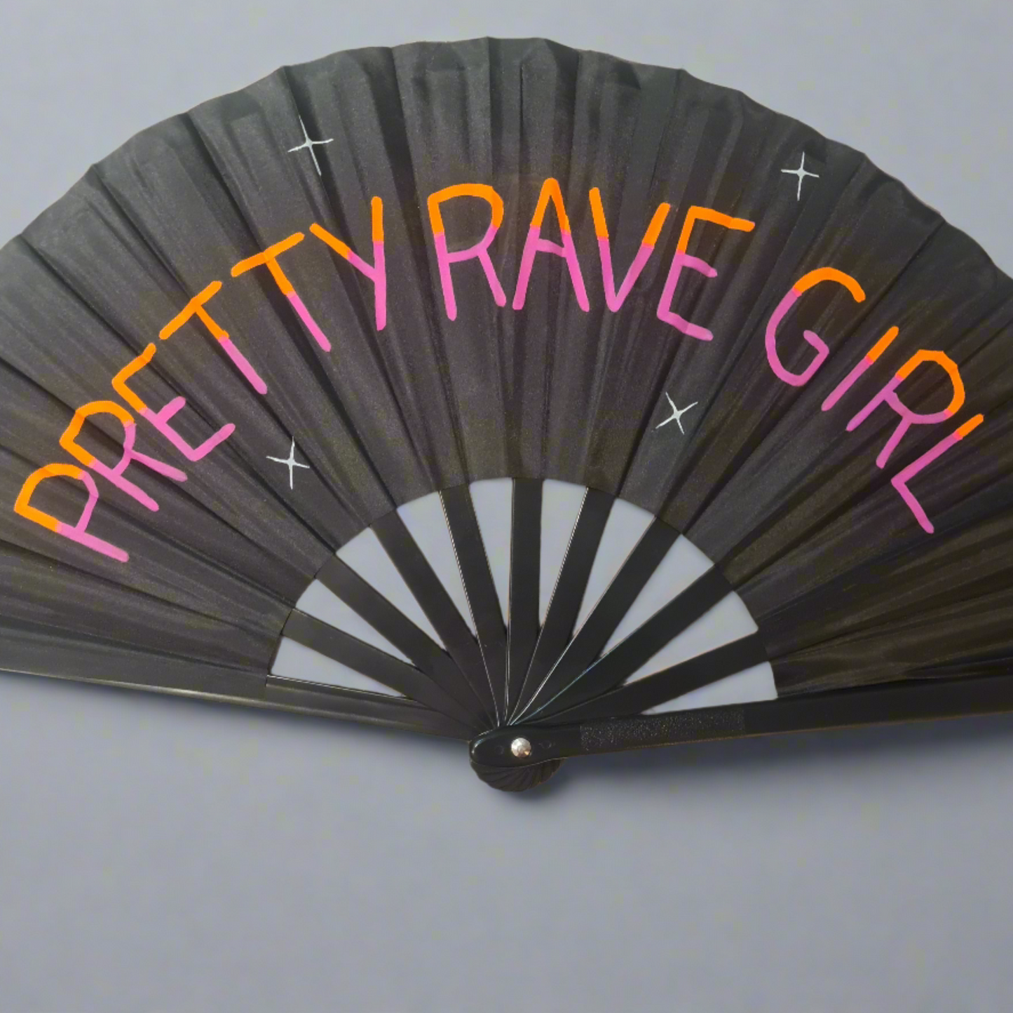 Pretty Rave Girl UV Fan, black handpainted with orange and pink lettering and white star, UV reactive for festivals and raves