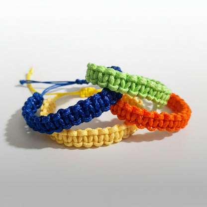 Four colorful braided bracelets on a light gray background