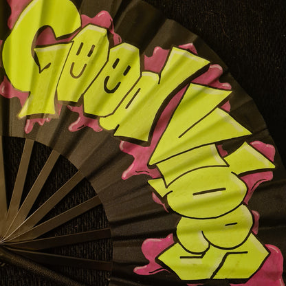 Good Vibes UV Fan, black handpainted with green graffiti lettering and purple paint splatter outline, UV reactive for festivals and raves
