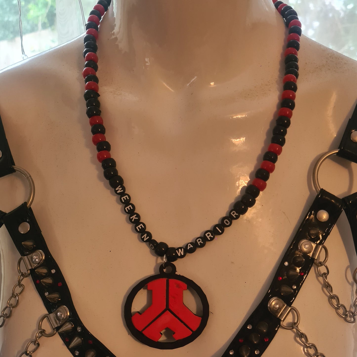 Necklace with red and black designs on a mannequin