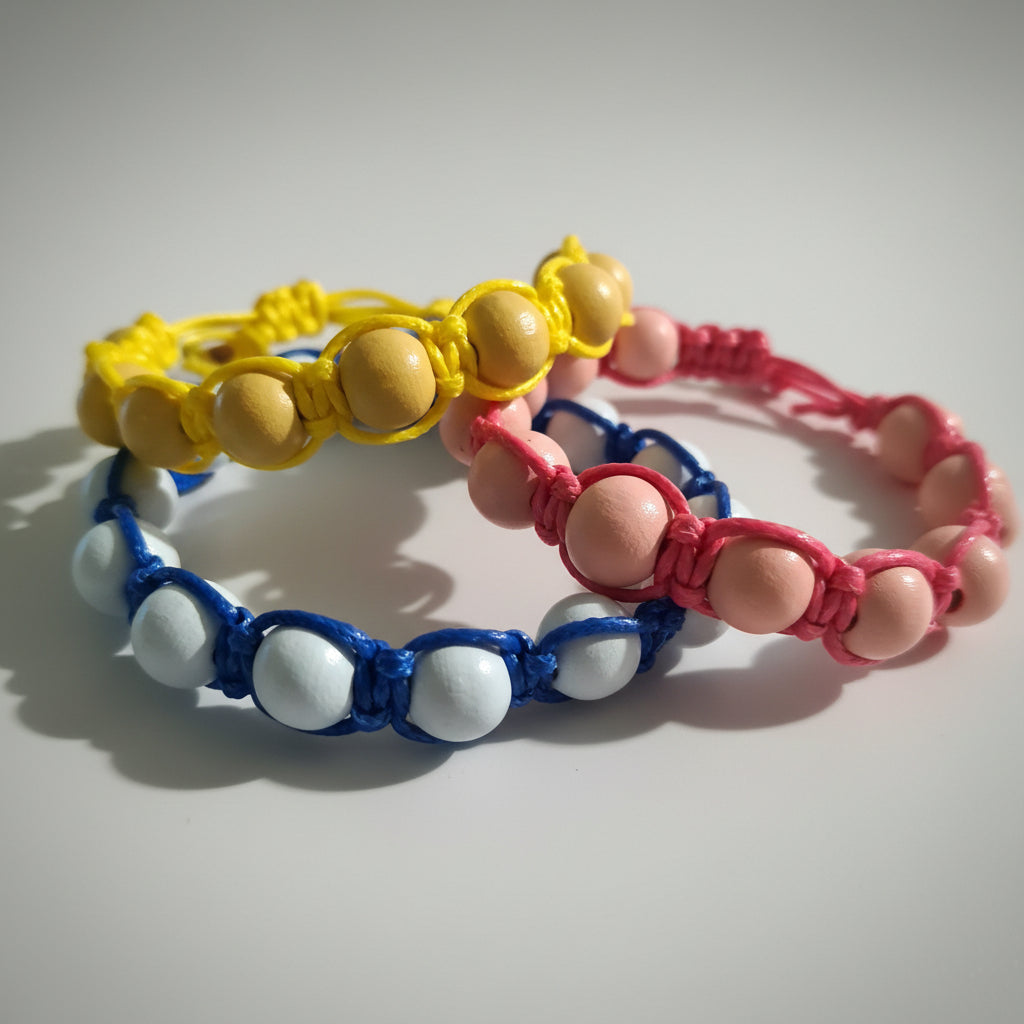 Three colorful beaded bracelets on a light gray background