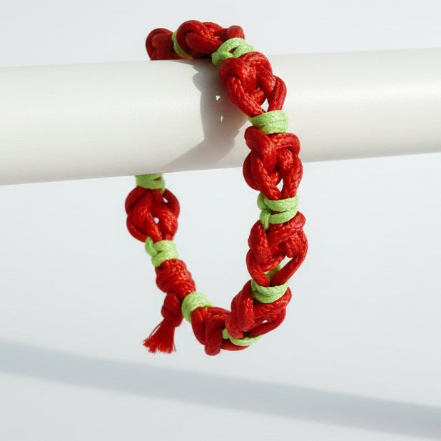 Red and green braided bracelet on a white surface