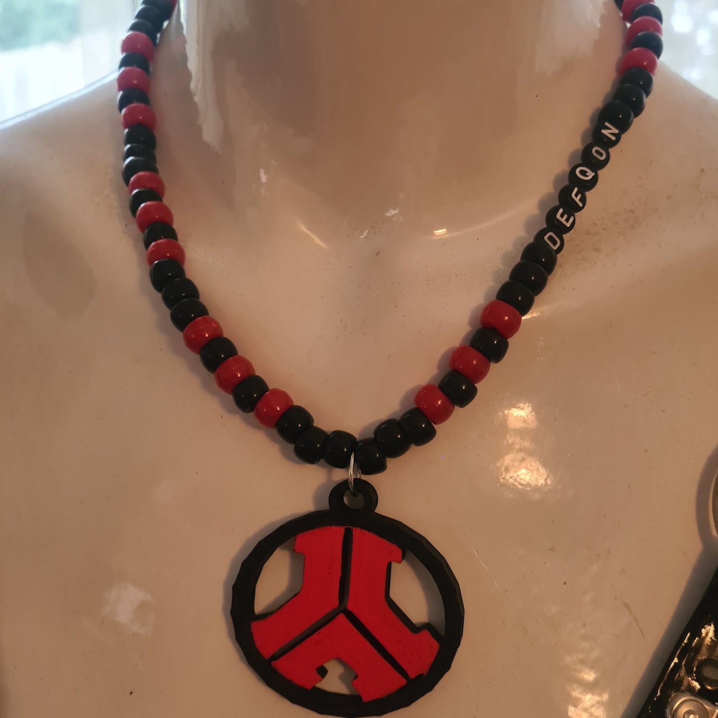 Necklace with red and black designs on a mannequin