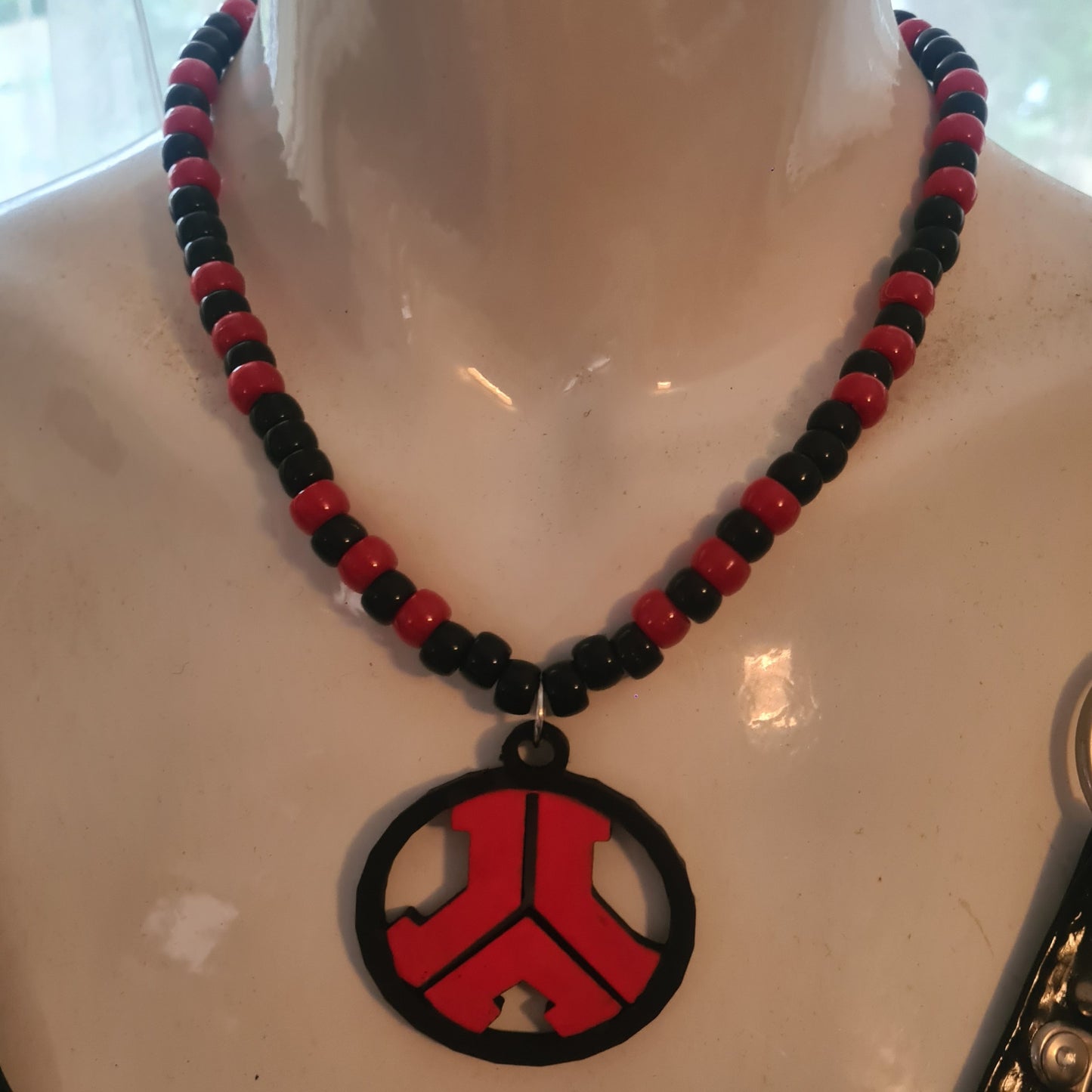 Necklace with red and black designs on a mannequin