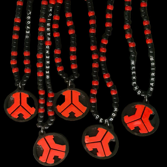 Necklaces with red and black designs on a gray surface